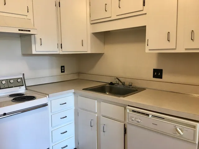a view of a kitchen with wooden floor and a sink