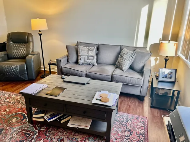 a living room with furniture and a wooden floor