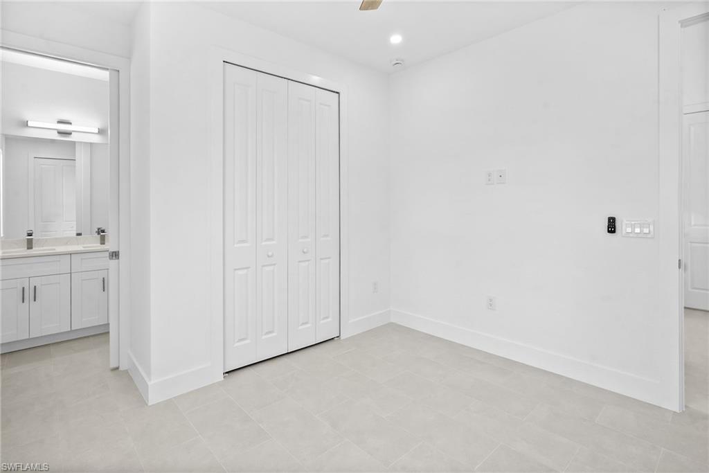 2936 40th Avenue Southeast Naples, FL 34117 - Photo 15 of 49 Unfurnished bedroom featuring a closet, ceiling fan, connected bathroom, and recessed lighting