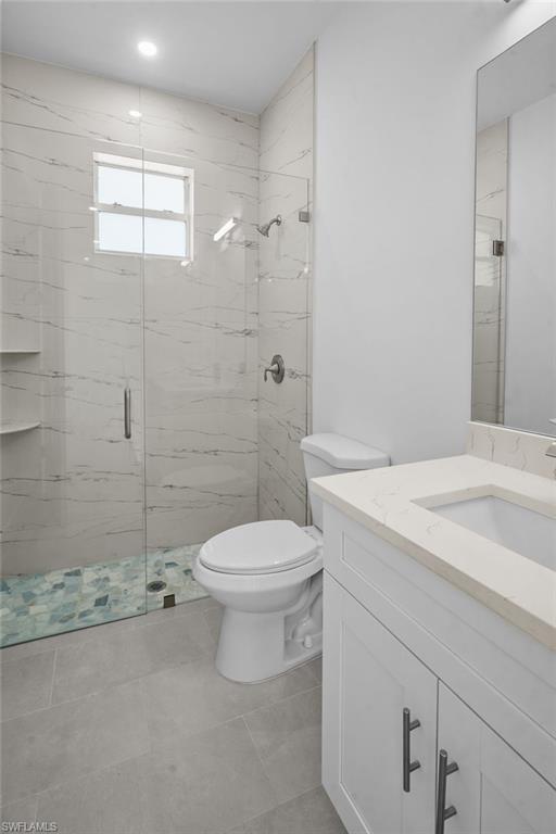 2936 40th Avenue Southeast Naples, FL 34117 - Photo 20 of 49 Bathroom featuring vanity, a marble finish shower, and light tile patterned floors