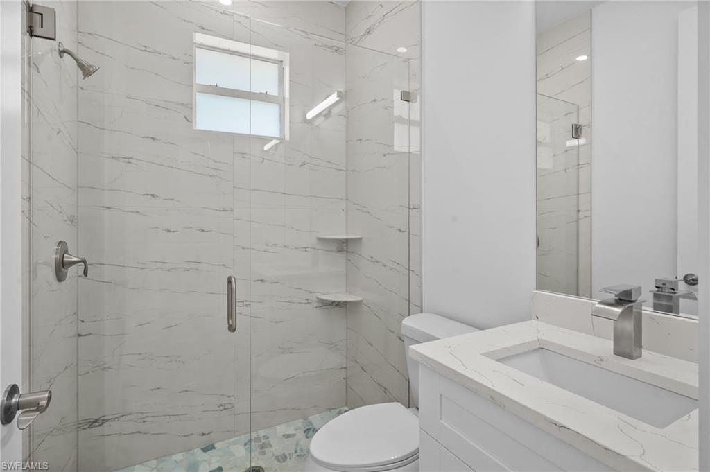 2936 40th Avenue Southeast Naples, FL 34117 - Photo 38 of 49 Bathroom featuring a marble finish shower and vanity