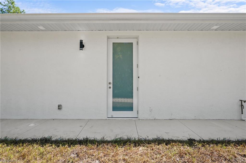 2936 40th Avenue Southeast Naples, FL 34117 - Photo 42 of 49 Entrance to property with stucco siding