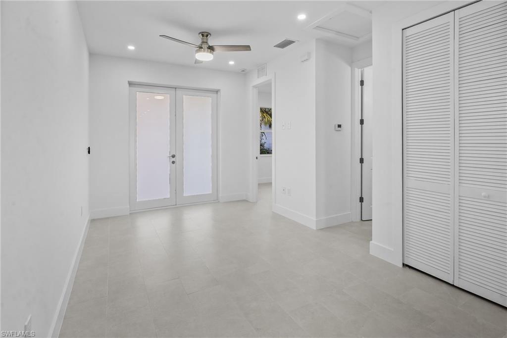 2936 40th Avenue Southeast Naples, FL 34117 - Photo 6 of 49 Unfurnished room featuring a ceiling fan, recessed lighting, french doors, and attic access