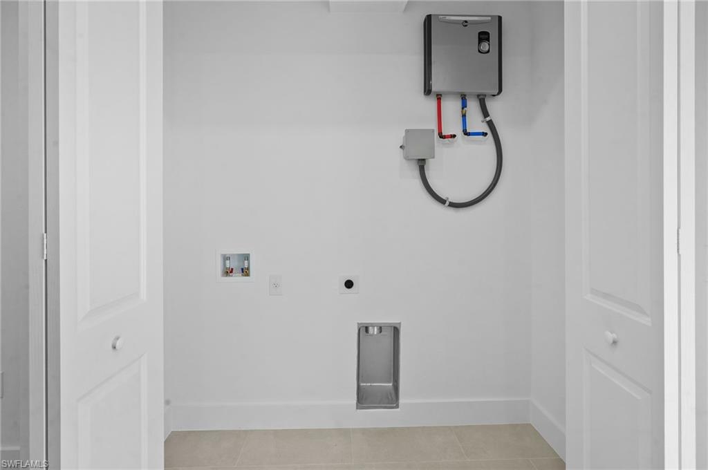 2936 40th Avenue Southeast Naples, FL 34117 - Photo 10 of 49 Washroom with tile patterned flooring, hookup for a washing machine, and electric dryer hookup