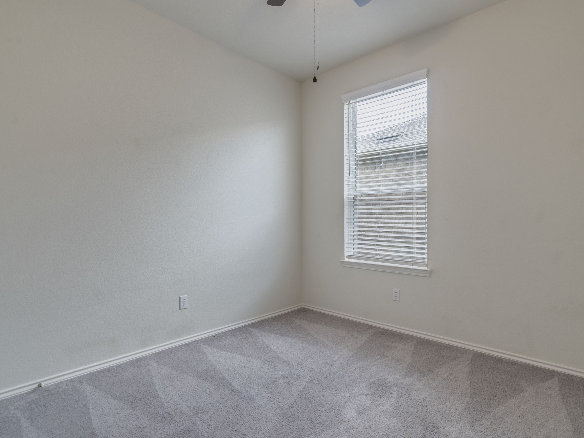 790 Pepperbark Loop Buda, TX 78610 - Photo 14 of 22 An inviting secondary bedroom featuring plush carpeting and a large window for natural light.