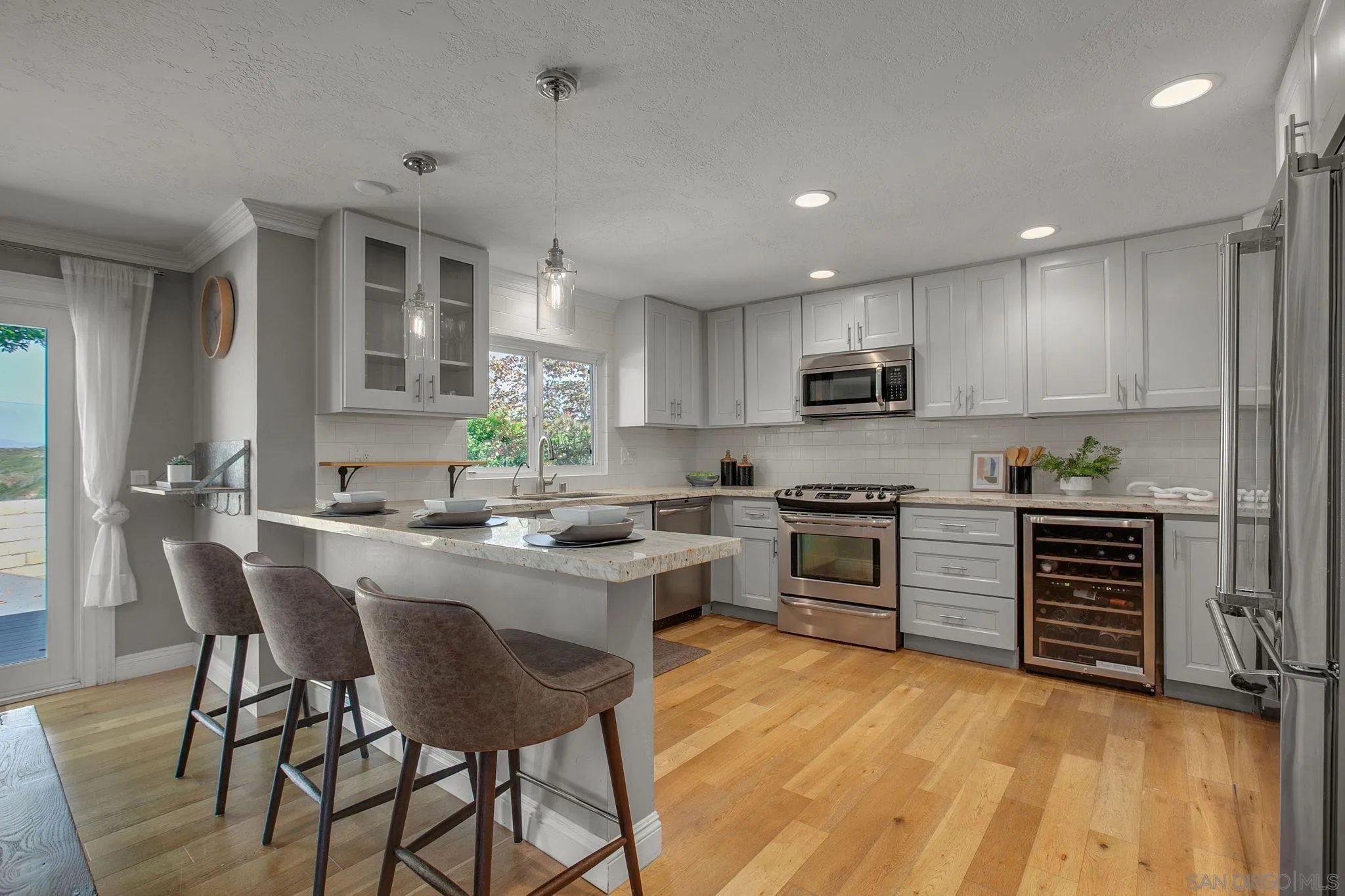 1625 Eolus Avenue Encinitas, CA 92024 - Photo 8 of 37 a kitchen with microwave a stove and chairs