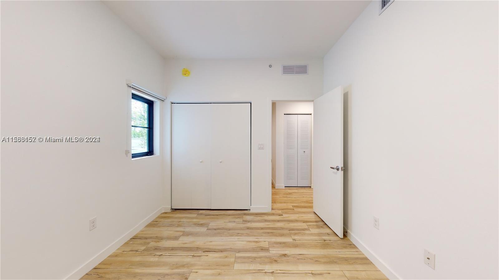 24705 Southwest 129th Avenue, Unit 109 Homestead, FL 33032 - Photo 12 of 22 a view of a hallway with wooden floor