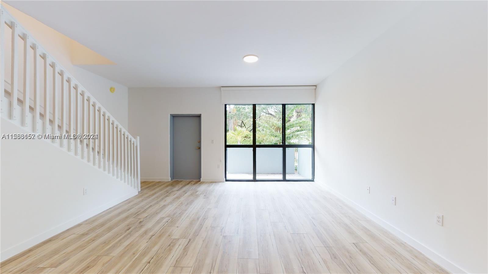 24705 Southwest 129th Avenue, Unit 109 Homestead, FL 33032 - Photo 15 of 22 wooden floor in an empty room with a window