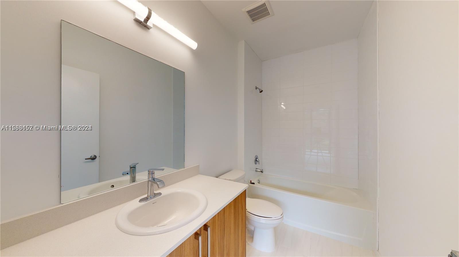24705 Southwest 129th Avenue, Unit 109 Homestead, FL 33032 - Photo 16 of 22 a bathroom with a sink a toilet and shower
