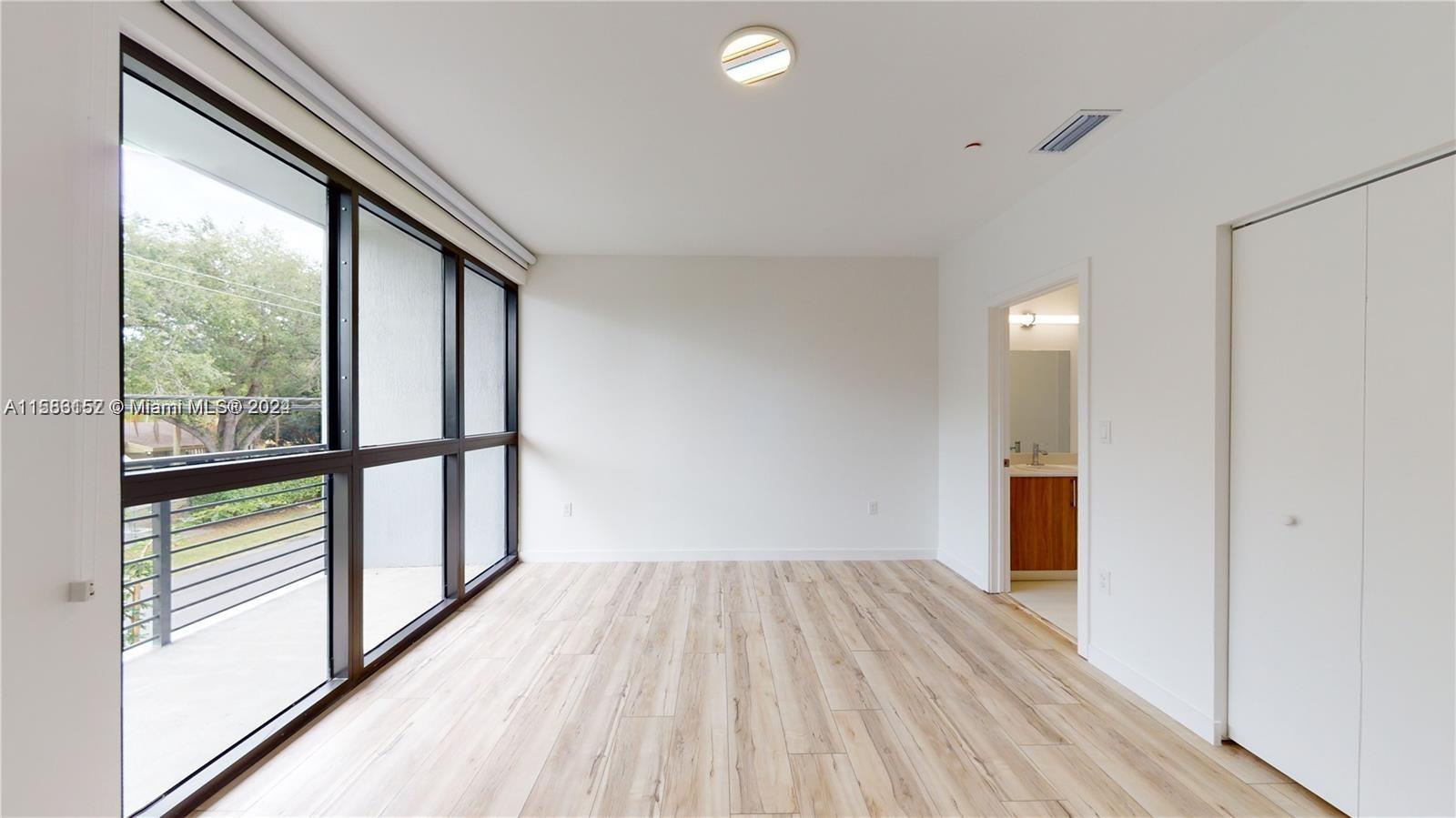 24705 Southwest 129th Avenue, Unit 109 Homestead, FL 33032 - Photo 17 of 22 a view of hallway with a large window and wooden floor