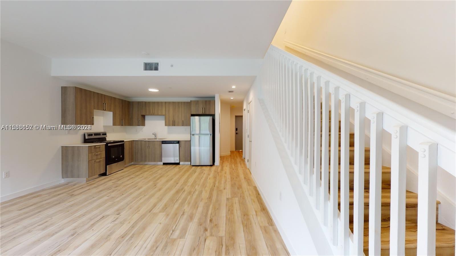 24705 Southwest 129th Avenue, Unit 109 Homestead, FL 33032 - Photo 2 of 22 a view of a kitchen with wooden floor