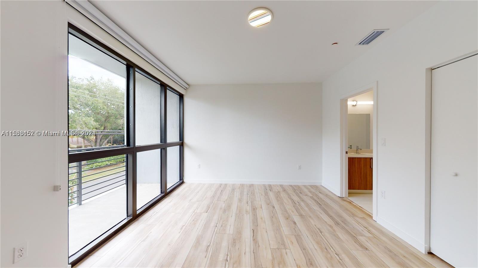 24705 Southwest 129th Avenue, Unit 109 Homestead, FL 33032 - Photo 4 of 22 a view of hallway with a large window and wooden floor