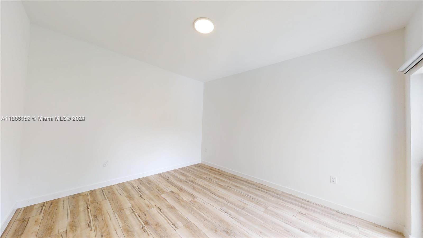 24705 Southwest 129th Avenue, Unit 109 Homestead, FL 33032 - Photo 6 of 22 a view of empty room with wooden floor