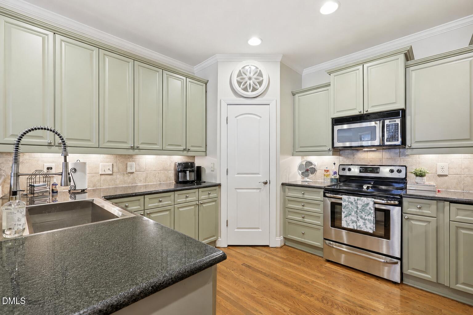 7040 Dayton Ridge Drive Apex, NC 27539 - Photo 11 of 38 a kitchen with stainless steel appliances granite countertop a stove a sink and a microwave