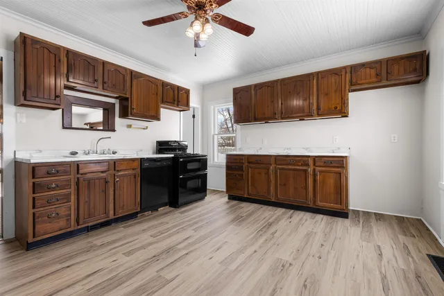 a kitchen with stainless steel appliances kitchen island wooden cabinets and a stove top oven
