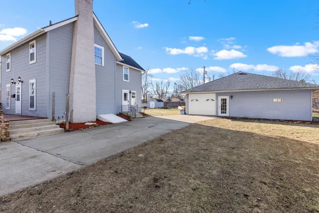 a view of a house with a backyard and a garage