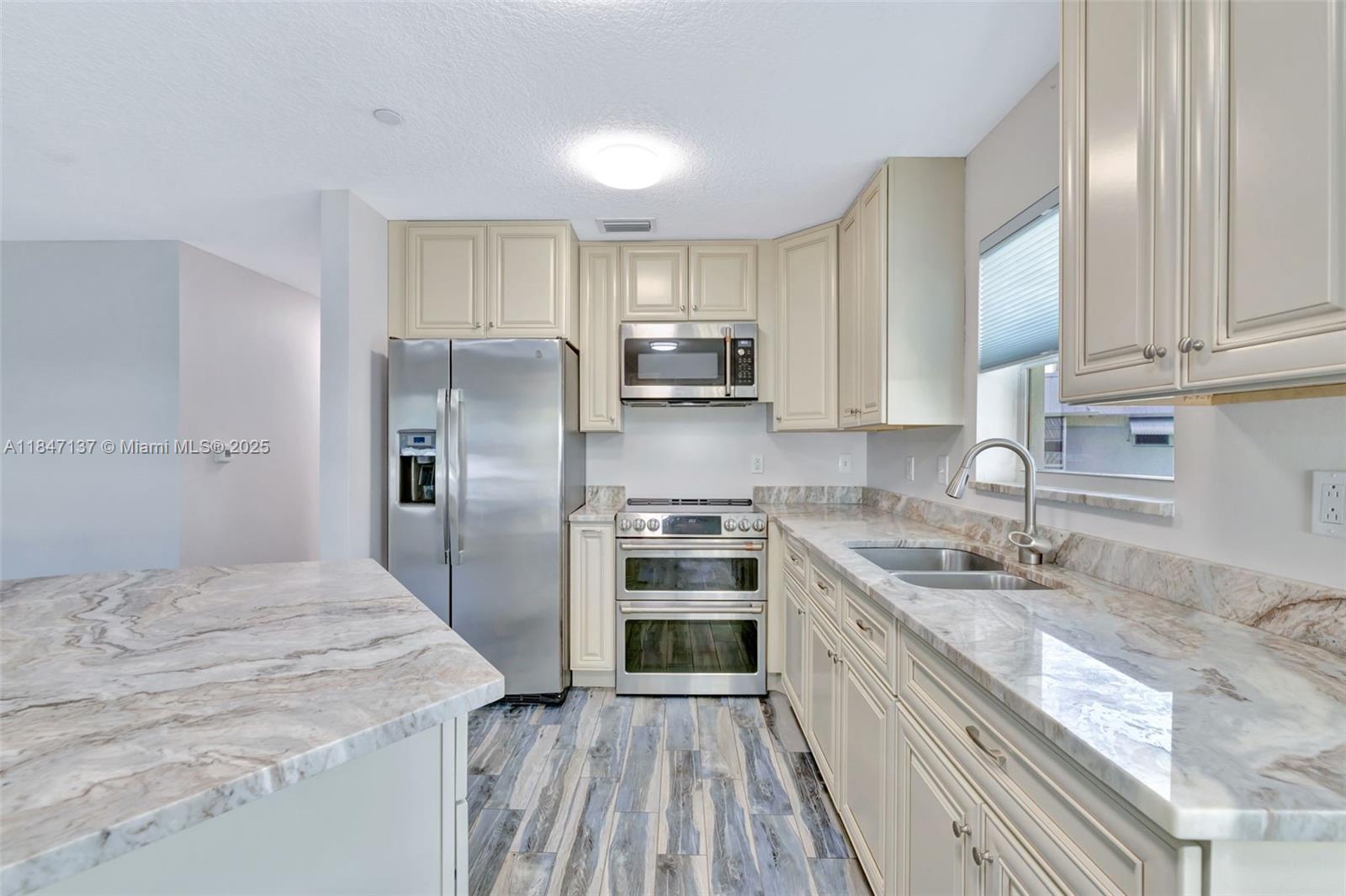 2929 Southeast Ocean Boulevard, Unit F6 Stuart, FL 34996 - Photo 2 of 42 a kitchen with a sink stove and refrigerator
