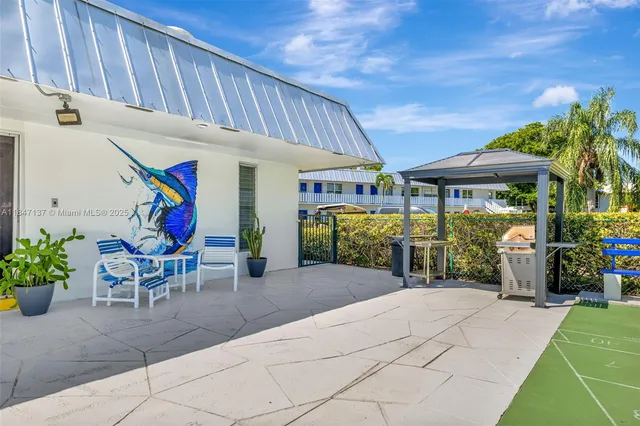 a front view of a house with patio furniture and garden
