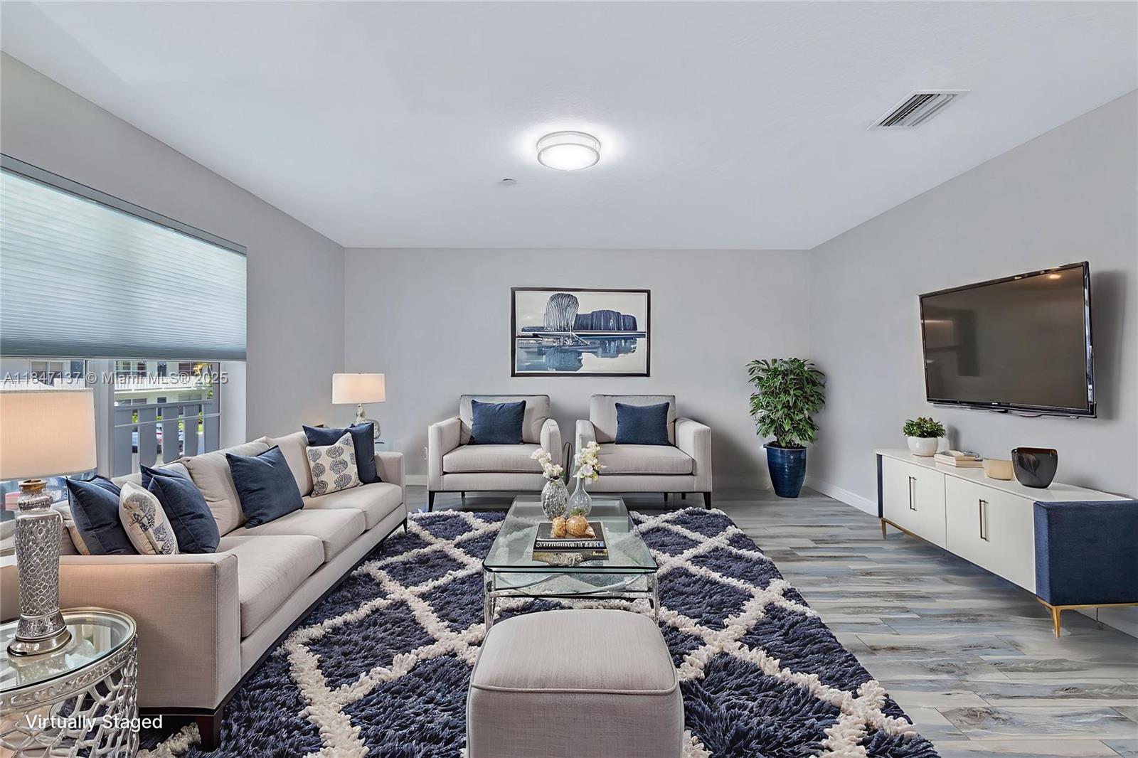 2929 Southeast Ocean Boulevard, Unit F6 Stuart, FL 34996 - Photo 4 of 42 a living room with furniture and a flat screen tv