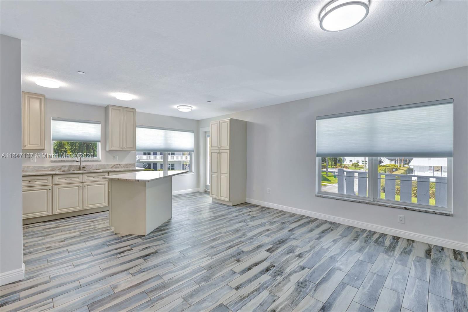 2929 Southeast Ocean Boulevard, Unit F6 Stuart, FL 34996 - Photo 8 of 42 a large white kitchen with wooden floors and view living room