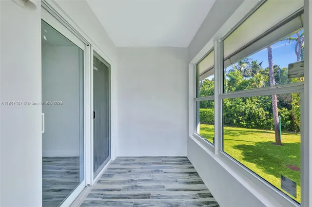 a view of hallway with wooden floor and a floor to ceiling window