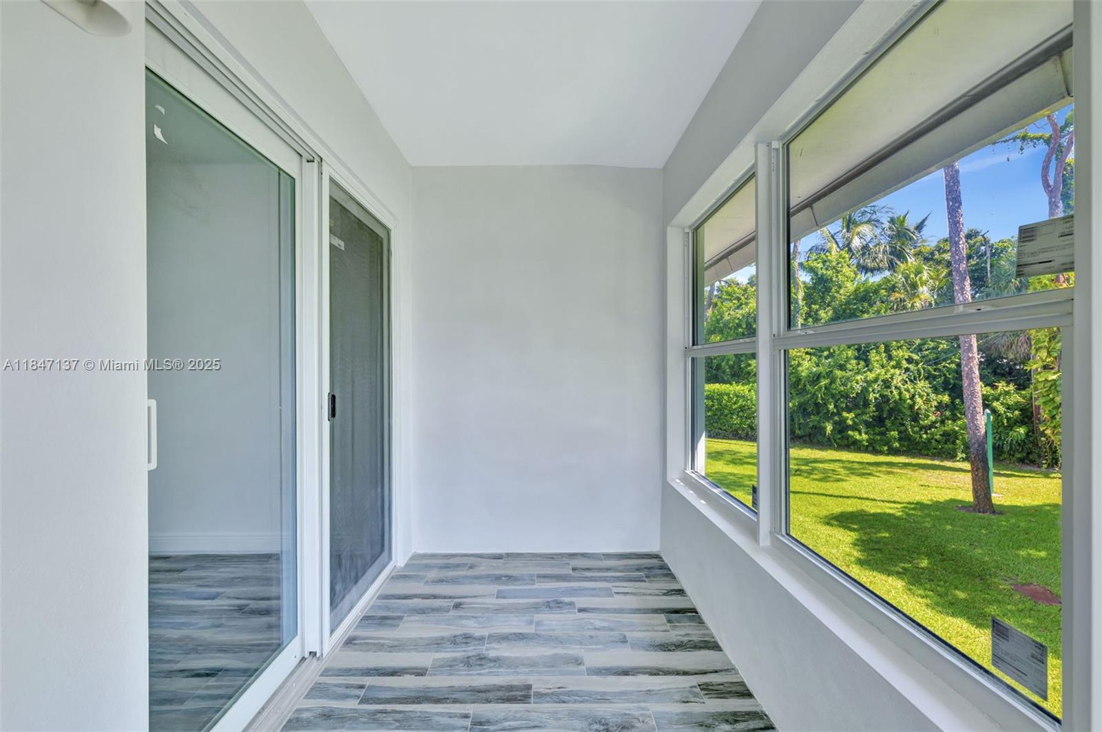 2929 Southeast Ocean Boulevard, Unit F6 Stuart, FL 34996 - Photo 9 of 42 a view of hallway with wooden floor and a floor to ceiling window