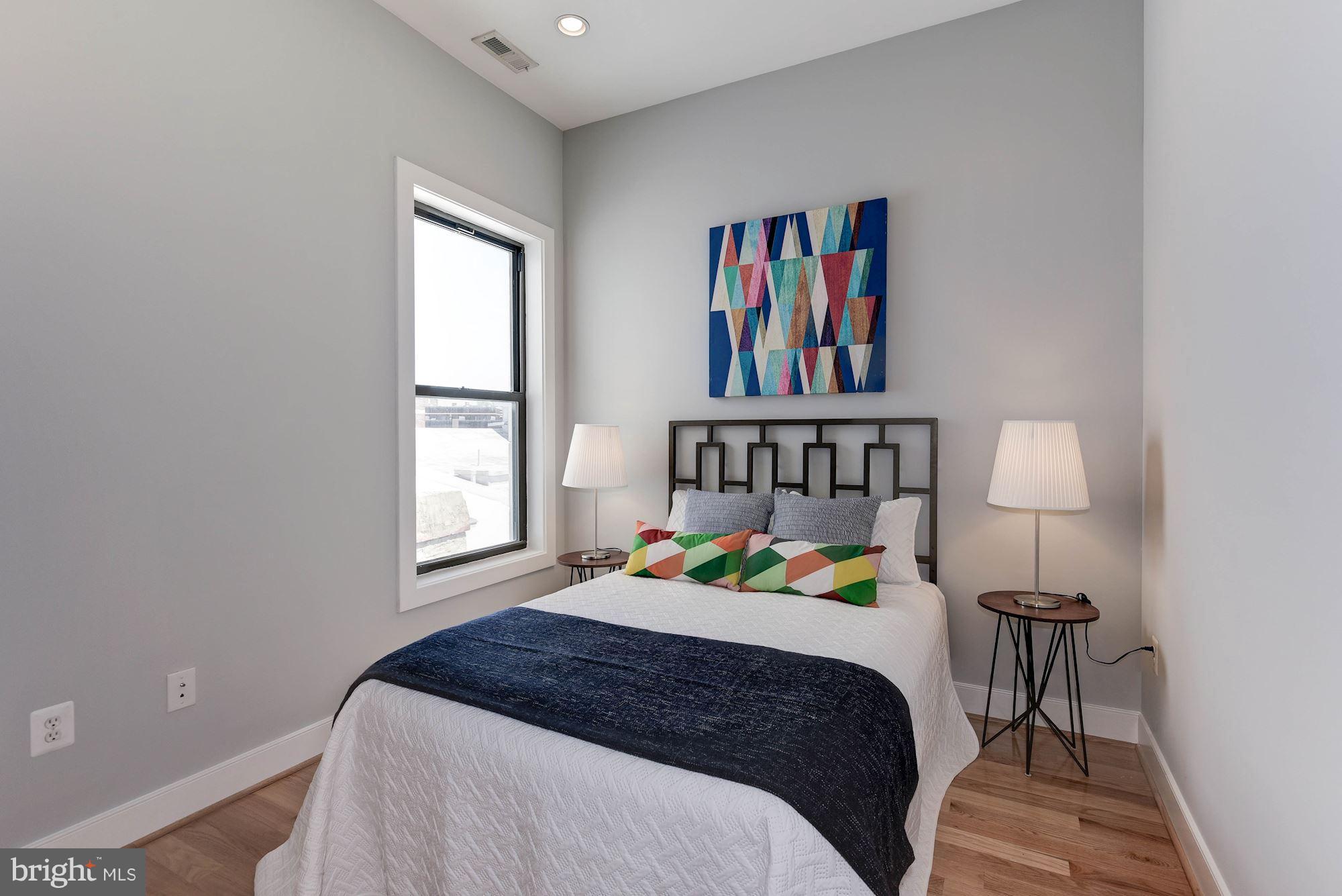 2444 Ontario Road Northwest, Unit 4 Washington, DC 20009 - Photo 20 of 26 a bedroom with a bed a painting and a window