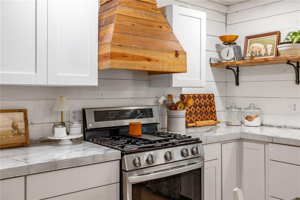 385 Amy's Road Clarkesville, GA 30523 - Photo 18 of 57 a kitchen with granite countertop a stove and a white cabinets