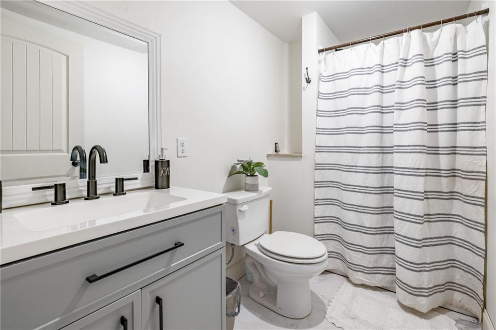 385 Amy's Road Clarkesville, GA 30523 - Photo 35 of 57 a bathroom with a sink a toilet and shower curtain