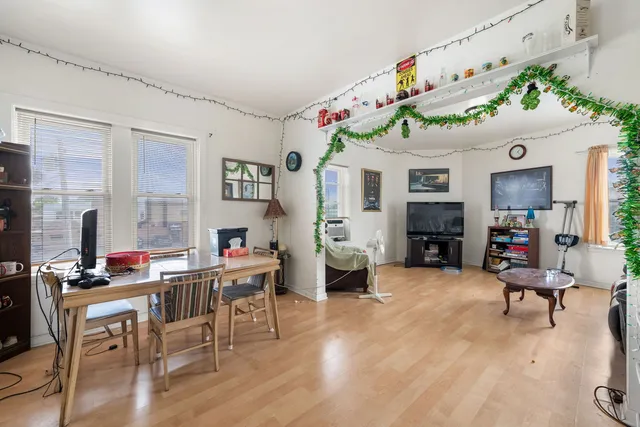 a living room with furniture kitchen area and a window
