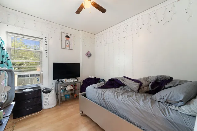 a bedroom with a bed and a flat tv screen on the dresser