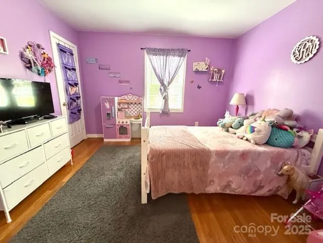 a bedroom with a bed and a flat screen tv on dresser