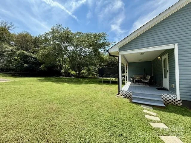 a view of a chair and table in backyard of the house