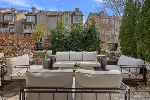 a view of a patio with couches table and chairs and potted plants