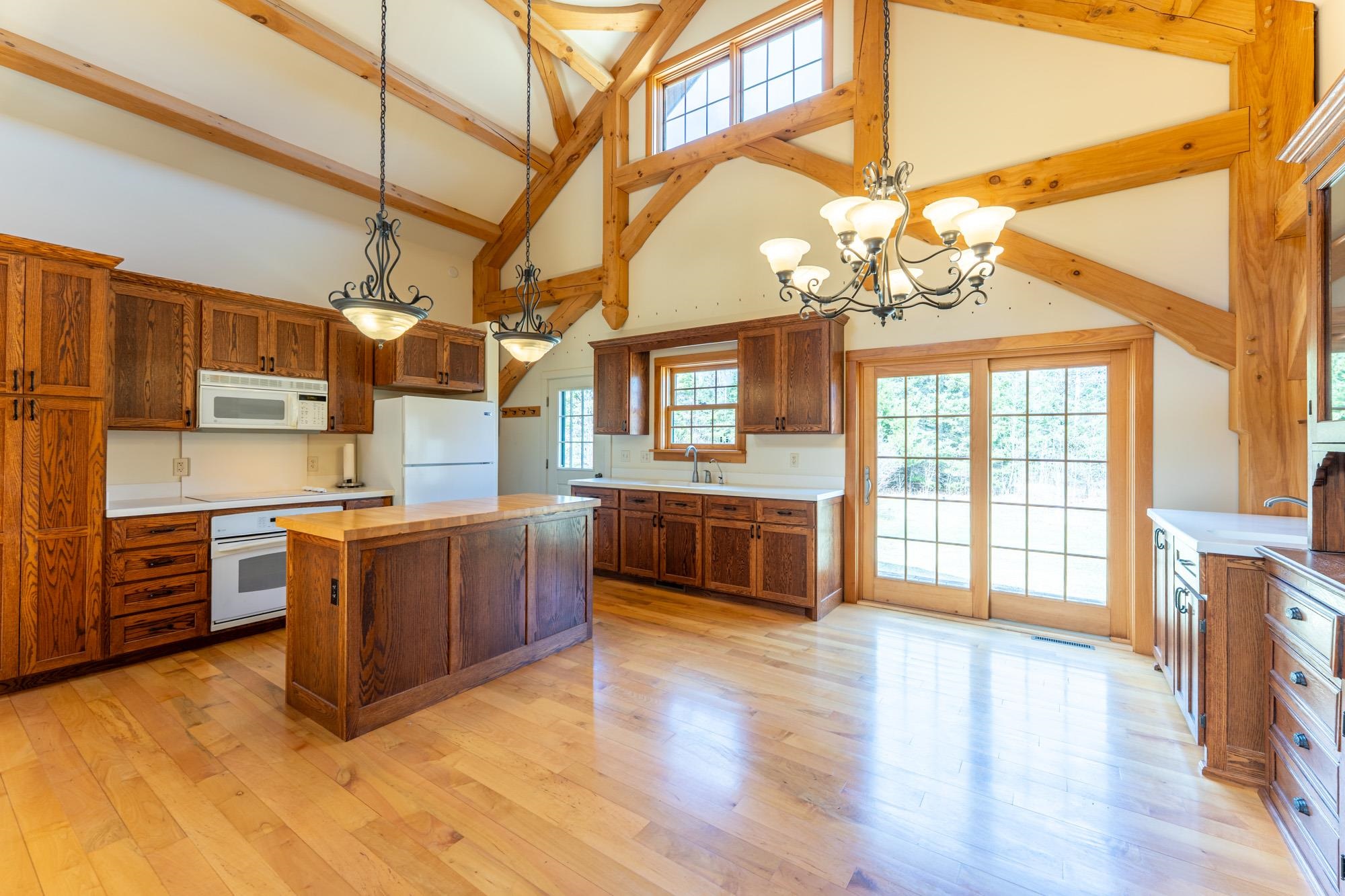 2263 Longstorff Road Ely, MN 55731 - Photo 7 of 49 Kitchen with a kitchen island, white appliances, beamed ceiling, high vaulted ceiling, combined with dining