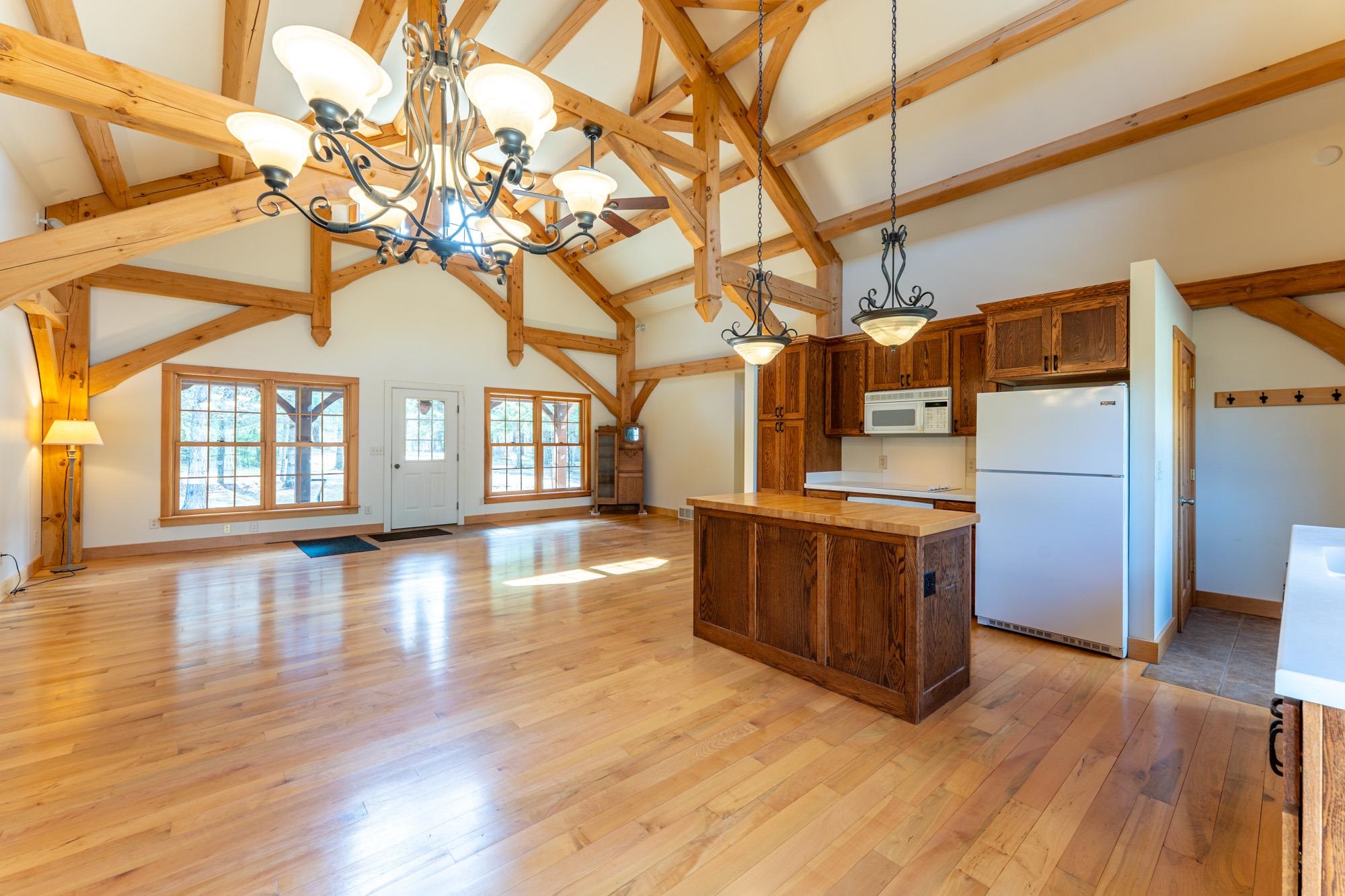 2263 Longstorff Road Ely, MN 55731 - Photo 48 of 49 Kitchen featuring white appliances, open floor plan, high vaulted ceiling, a center island, and a notable chandelier