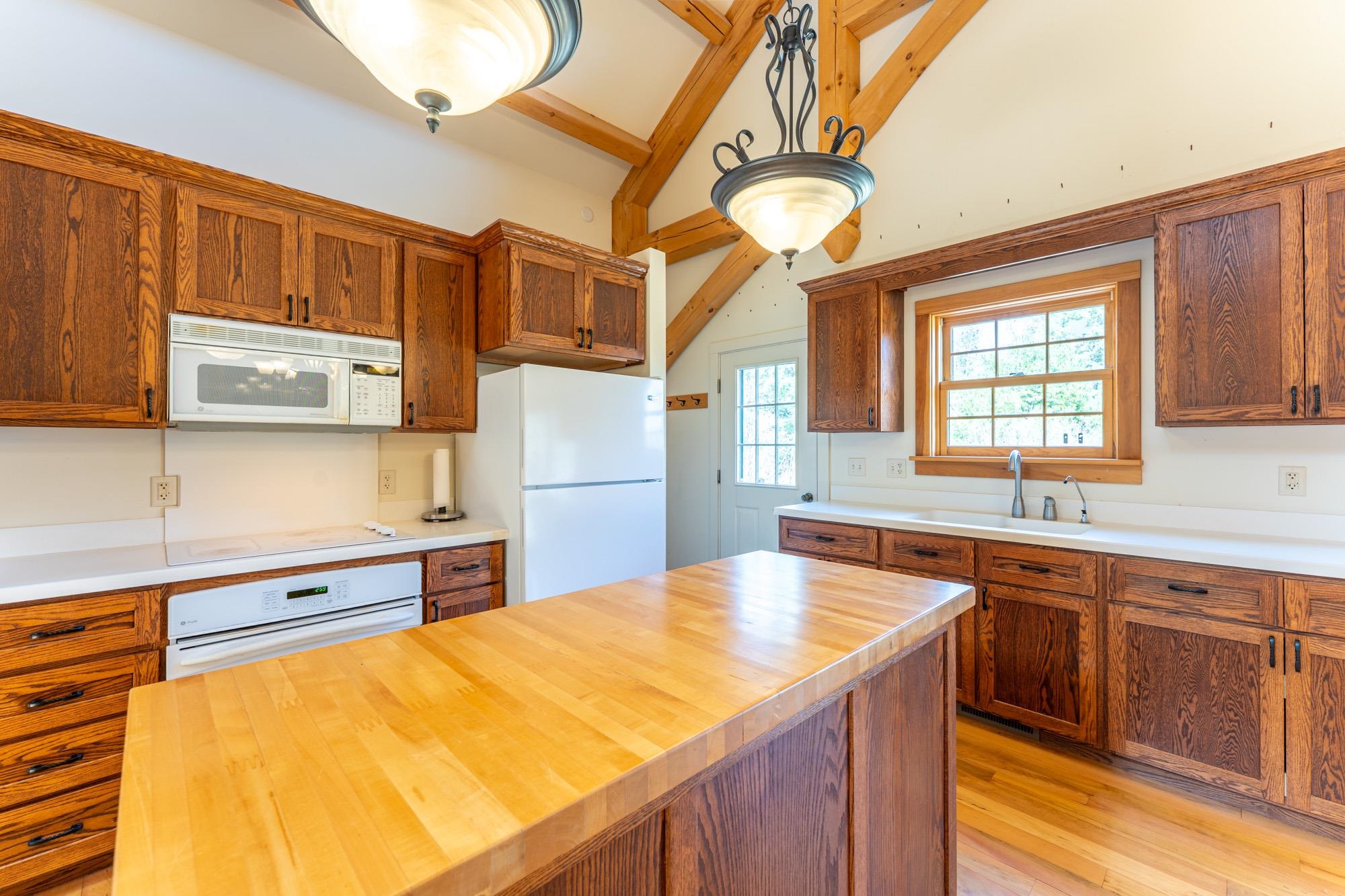 2263 Longstorff Road Ely, MN 55731 - Photo 8 of 49 Kitchen with wooden counters, white appliances, vaulted ceiling with beams, light wood-type flooring, and a sink
