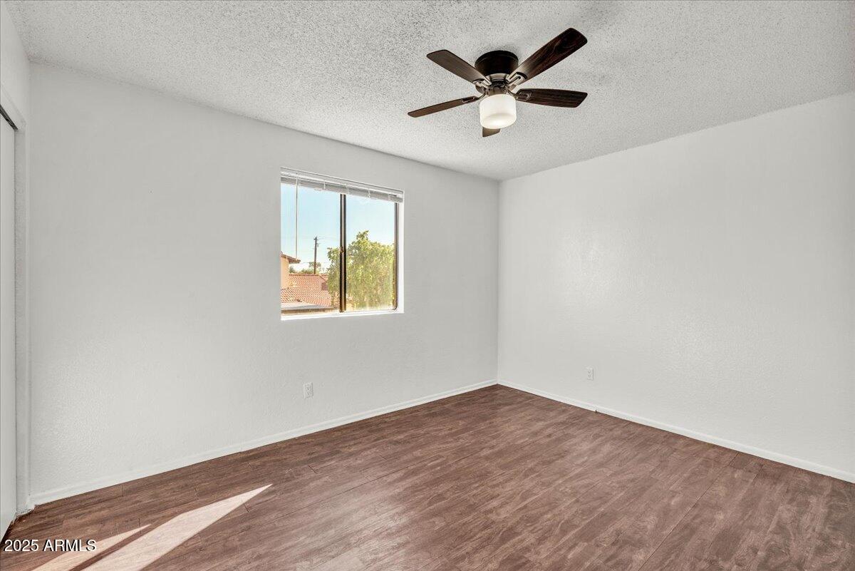 2437 East Tracy Lane, Unit 2 Phoenix, AZ 85032 - Photo 26 of 30 an empty room with a window and a ceiling fan