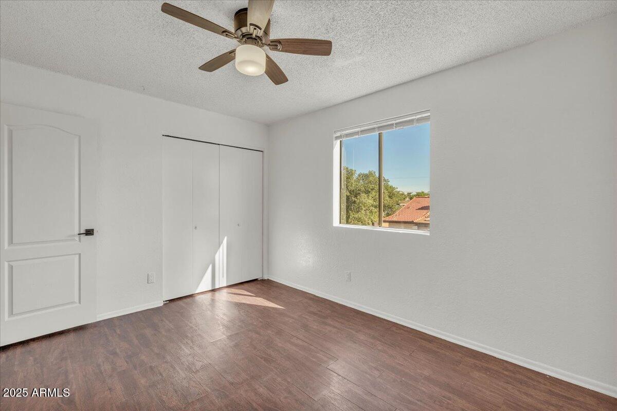 2437 East Tracy Lane, Unit 2 Phoenix, AZ 85032 - Photo 28 of 30 an empty room with wooden floor closet and ceiling fan window