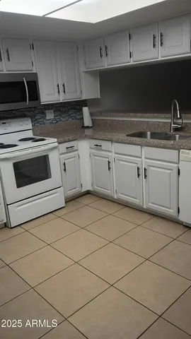 a kitchen with granite countertop a sink and a stove