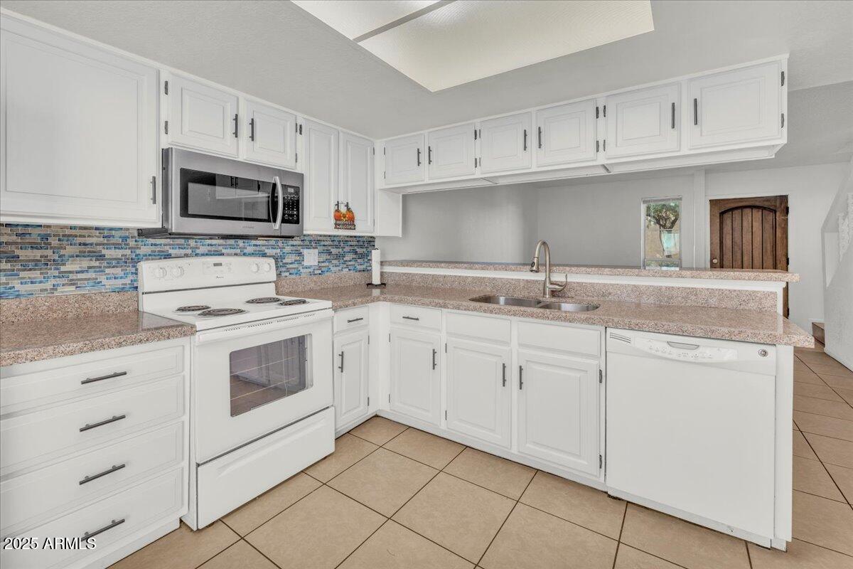 2437 East Tracy Lane, Unit 2 Phoenix, AZ 85032 - Photo 10 of 30 a kitchen with granite countertop white cabinets white stainless steel appliances with a sink and dishwasher