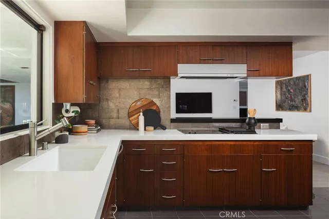 a kitchen with a sink and a stove with wooden floor