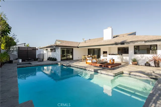 a view of a house with swimming pool and sitting area