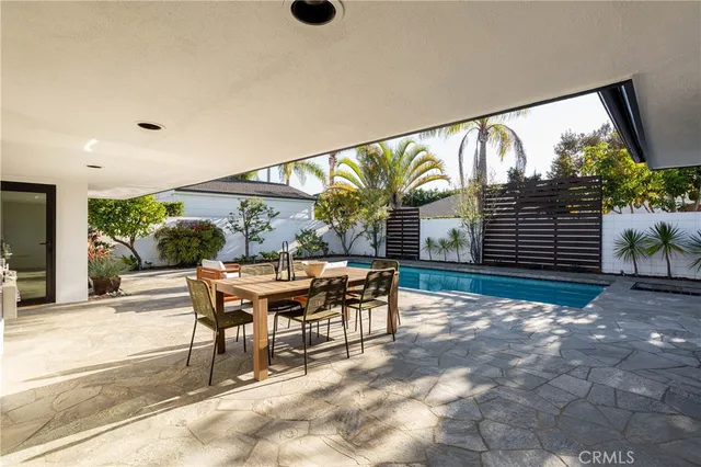 a view of a patio with a table and chairs and potted plants