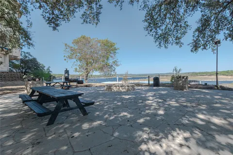 a view of a backyard with table and chairs and a fire pit