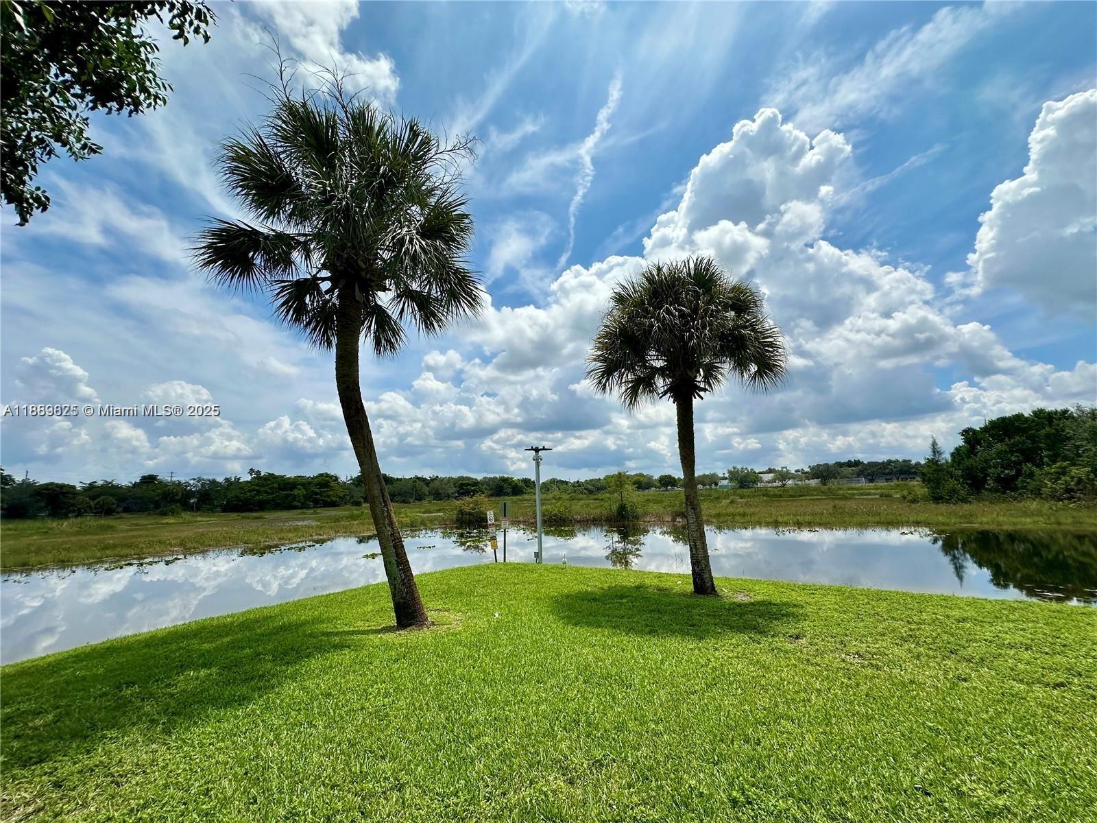 231 Southwest 116th Avenue, Unit 19108 Pembroke Pines, FL 33025 - Photo 17 of 56 a view of a lake with a yard