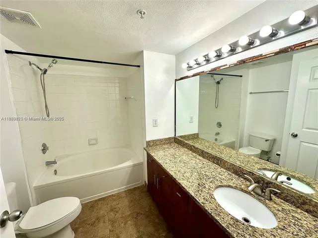 a bathroom with a tub shower and sink