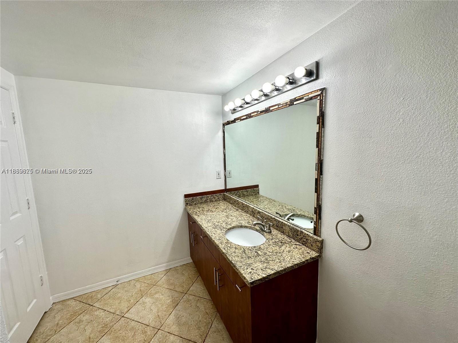 231 Southwest 116th Avenue, Unit 19108 Pembroke Pines, FL 33025 - Photo 29 of 56 a bathroom with a granite countertop sink and a mirror