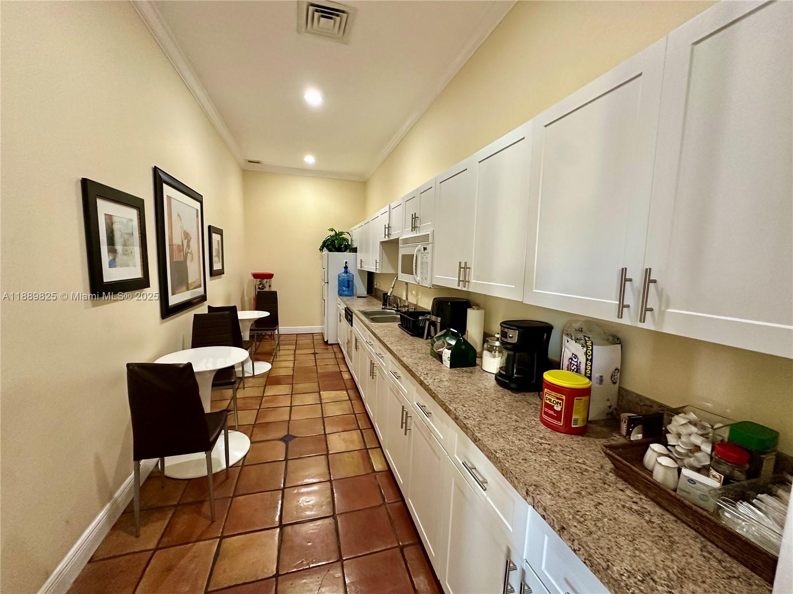 231 Southwest 116th Avenue, Unit 19108 Pembroke Pines, FL 33025 - Photo 45 of 56 a large kitchen with lots of counter and chairs