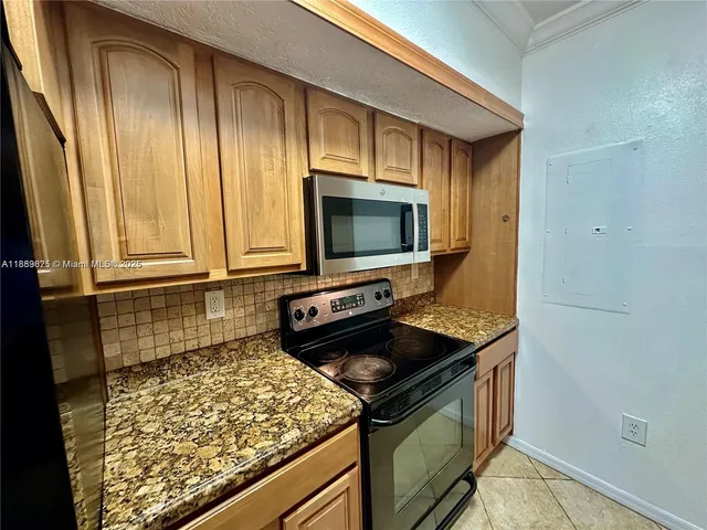 a living room with stainless steel appliances kitchen island granite countertop a sink and cabinets